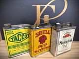 three vintage shell oil cans sitting on top of a wooden table