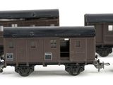 three brown train cars sitting side by side on a white surface