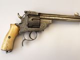 un vieux revolver avec une poignée en bois sur une surface blanche