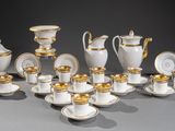 de nombreuses assiettes et tasses blanches et dorées sur la table