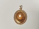 an image of a gold locke with a pearl in the center
