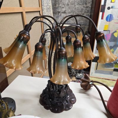 une table sur laquelle se trouve une lampe et un bouquet de fleurs