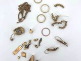 a group of gold rings and other jewelry on a white surface