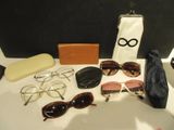 une table sur laquelle sont posées des lunettes de soleil, un sac à main et d'autres objets