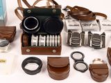 many different types of cameras and accessories laid out on the table