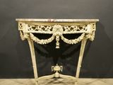 an ornately carved console table with marble top