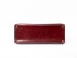 the red leather wallet is sitting on top of a white surface
