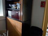 a black chair sitting in front of a cabinet in a living room