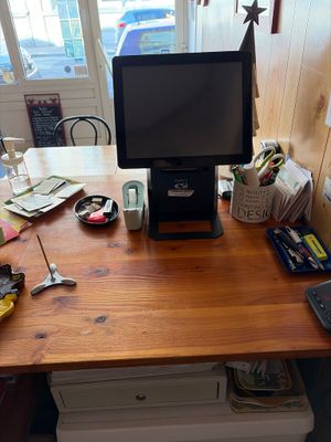 a desk with a monitor, keyboard, mouse, and other items on it