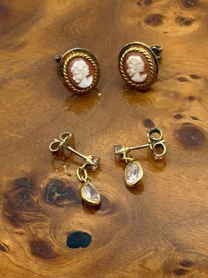deux paires de boucles d'oreilles et une bague posées sur une table en bois