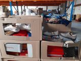 several boxes of shoes are stacked on top of each other in a warehouse
