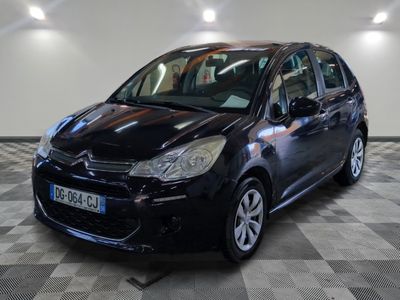 la petite voiture noire est garée sur un sol en damier