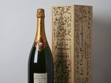 une bouteille de champagne posée à côté d'une boîte en bois sur une table