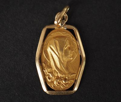 un gros plan sur un pendentif en or représentant une femme