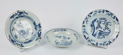 trois assiettes bleues et blanches et un bol posés sur un plan de travail blanc