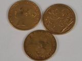 three gold coins sitting next to each other on a white surface