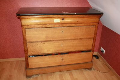 a wooden dresser with a black top in a room
