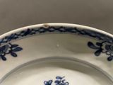 a blue and white plate with a flower design on it