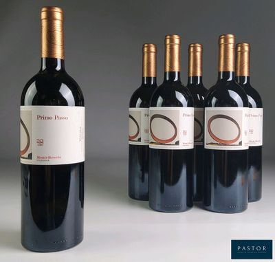 quatre bouteilles de vin rouge sont alignées sur une table