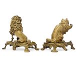 pair of bronze figurines of lions sitting on a tree branch