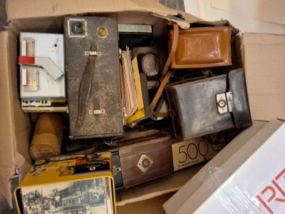 un carton rempli de vieilles valises et d'autres objets