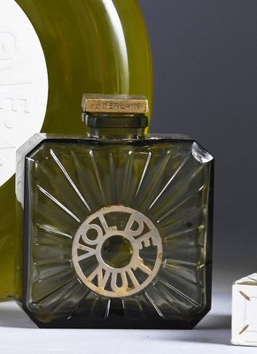 a bottle of perfume sitting next to a bottle of wine