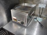 un plan de travail en acier inoxydable dans une cuisine professionnelle, sur lequel est posé un grille-pain