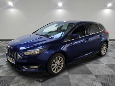 Une Ford Focus bleue est garée dans une pièce dont le sol est en damier.