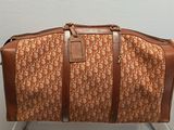 un sac de voyage marron et blanc posé sur une chaise