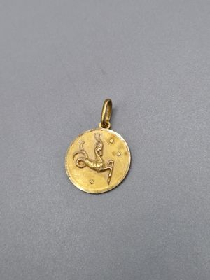 un pendentif plaqué or orné d'un signe du zodiaque