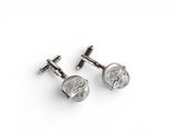 a pair of silver cufflinks on a white background