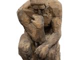 an image of a sculpture of a man sitting on a rock
