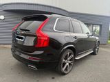 the rear end of a black volvo suv parked in front of a building