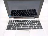 a laptop computer with a keyboard on a white surface