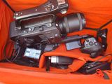 an orange bag with a camera and other electronics in it