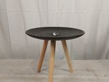 une petite table noire aux pieds en bois sur fond blanc