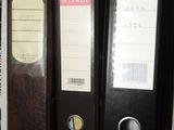 trois classeurs posés sur une étagère