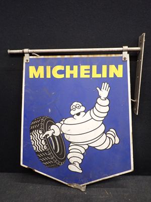 une vieille enseigne « Michel Tire » accrochée à un mur noir