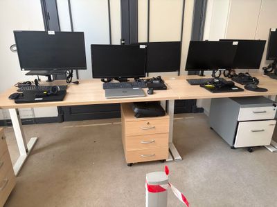 a desk with three computer monitors and a printer on it