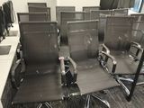 rows of office chairs in a conference room with computers on the desks