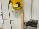 un tuyau jaune fixé au mur à côté d'une échelle