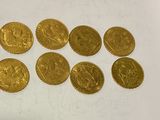 a close up of a bunch of gold coins on a white surface