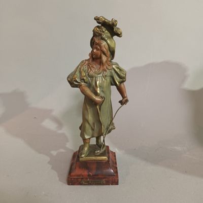 a bronze statue of a woman holding a cane