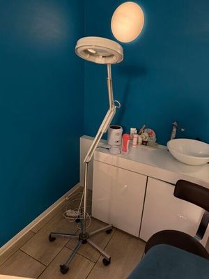 une pièce dans laquelle se trouvent une chaise, un lavabo et une lampe