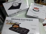 plusieurs cartons contenant des ustensiles de cuisine électriques posés sur une table dans un magasin