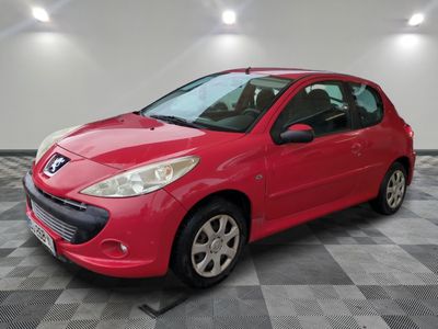 a red car is parked on a checkered floor in a garage