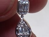 une personne tenant une paire de boucles d'oreilles en diamant dans la main