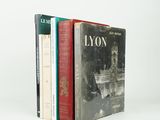 trois livres sont empilés sur une surface blanche