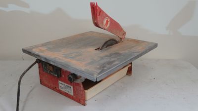 a small table saw on a table with a red flag on it