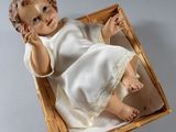 une poupée dans un panier posé sur une table